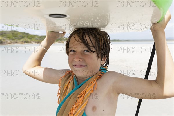 Boy with surfboard on beach