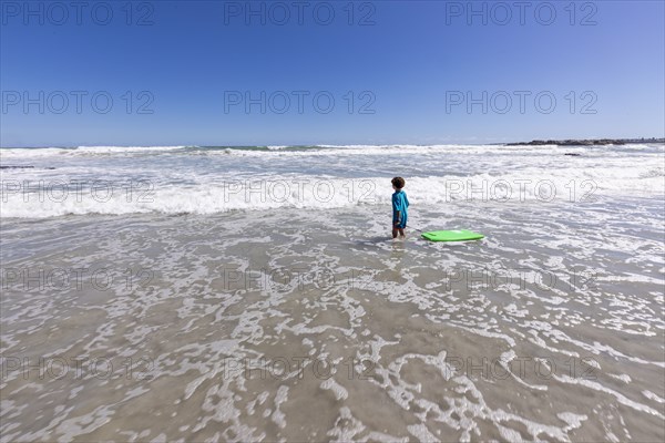 Boy with surfboard on beach