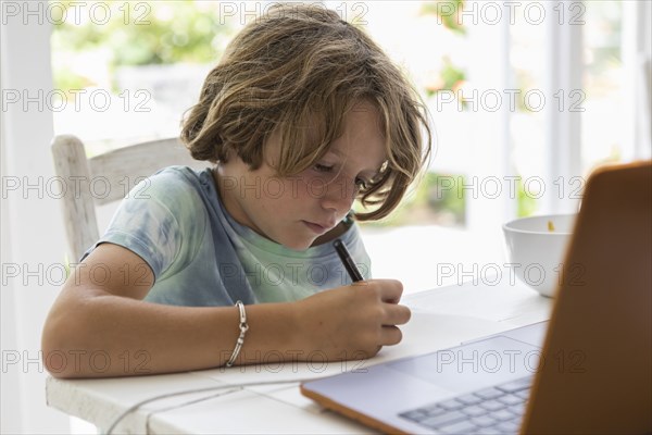 Boy drawing picture during online lesson