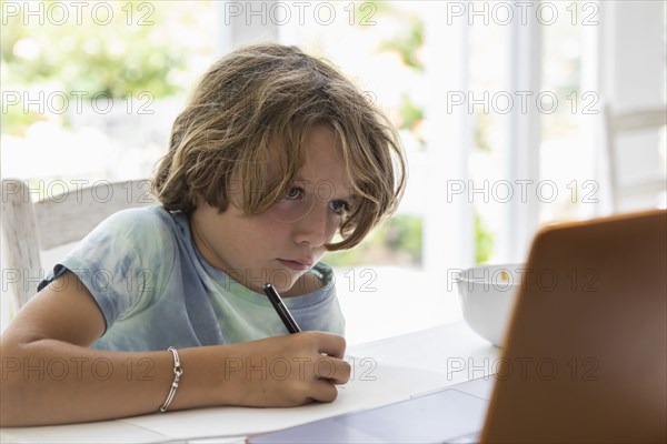 Boy drawing picture during online lesson