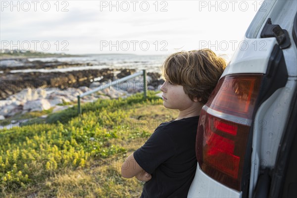 Boy leaning on SUV