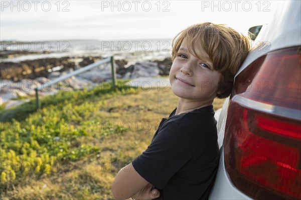 Portrait of Boy leaning on SUV