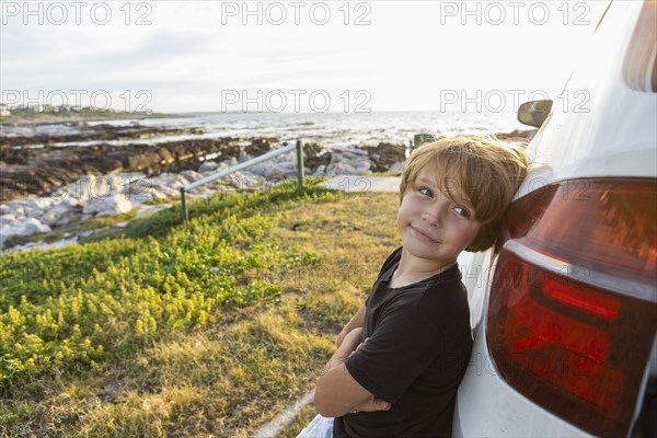 Portrait of Boy leaning on SUV