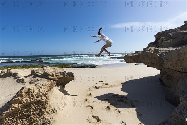 Girl jumping off rock