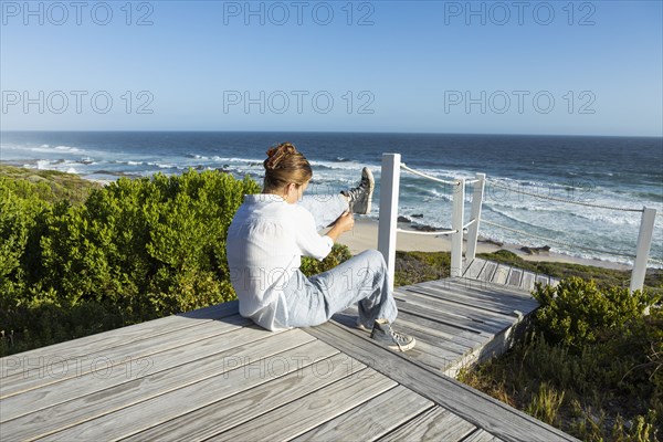Girl sitting on boardwalk