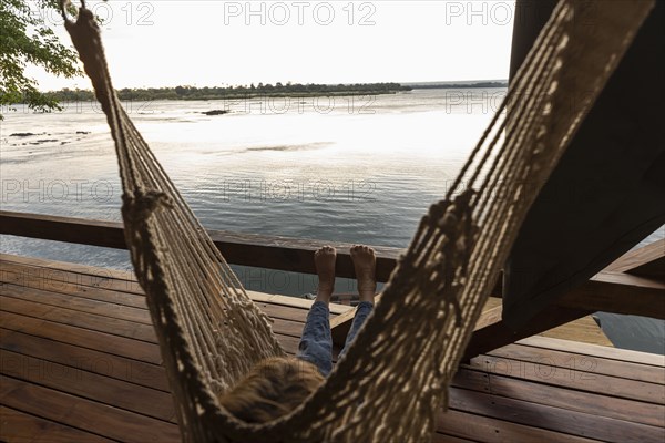 Boy relaxing in hammock by Zambezi River