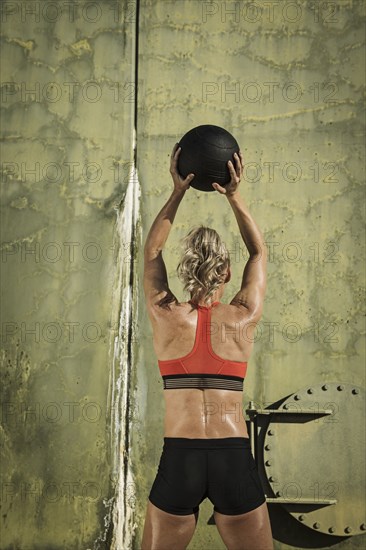 Rear view of woman exercising with ball