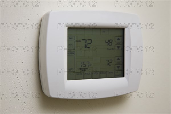 Home thermostat hanging on wall