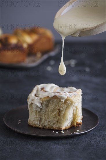 Cinnamon bun with icing on plate