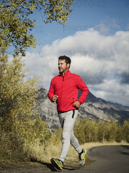 Man jogging on mountain road on sunny day