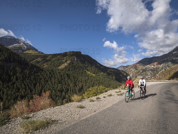 Man and woman riding bicycles on mountain road