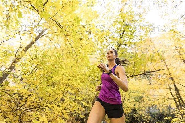 Woman jogging in Autumn forest