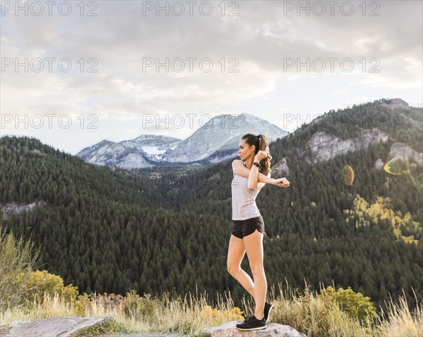 Woman stretching in mountain landscape