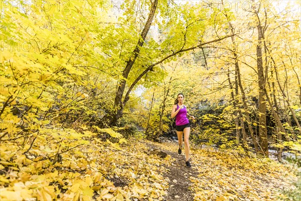 Woman jogging in Autumn forest