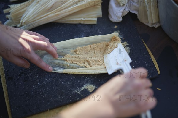 Person preparing tamales, close up