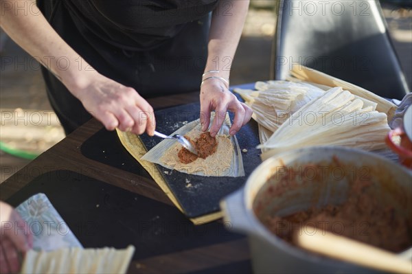 Person preparing tamales, close up