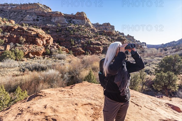 Senior hiker looking through binoculars