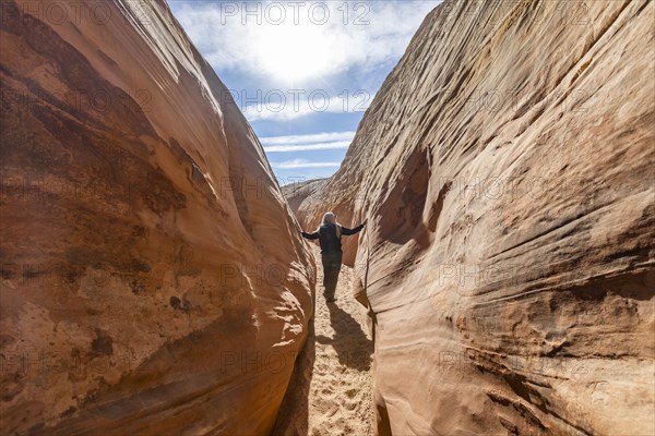 Senior hiker walking in sandstone canyon