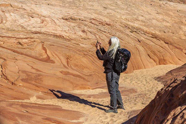 Senior hiker photographing rock formations