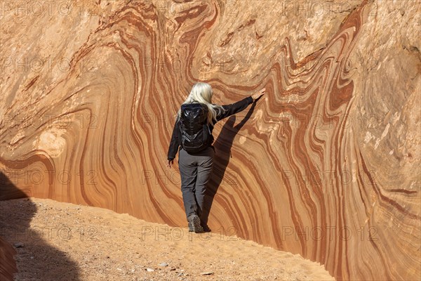Senior hiker exploring sandstone cliff