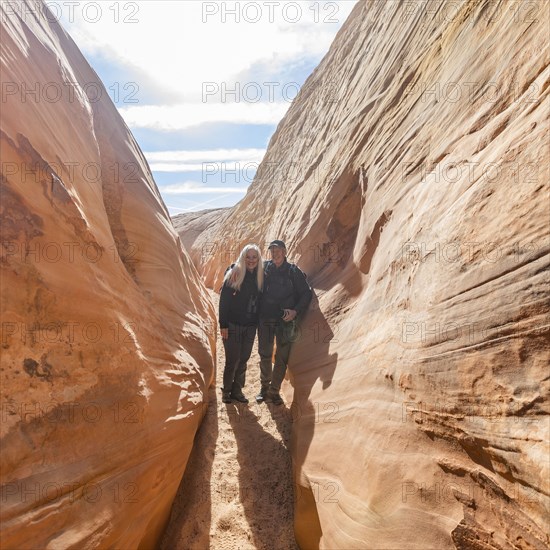 Senior hiker couple exploring slot canyon