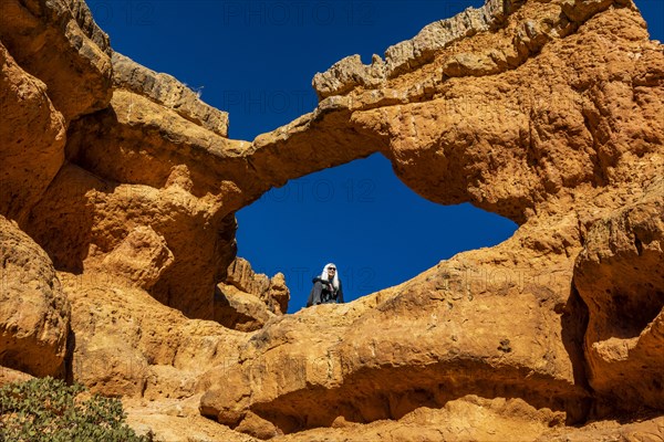 Senior hiker sitting on sandstone ledge