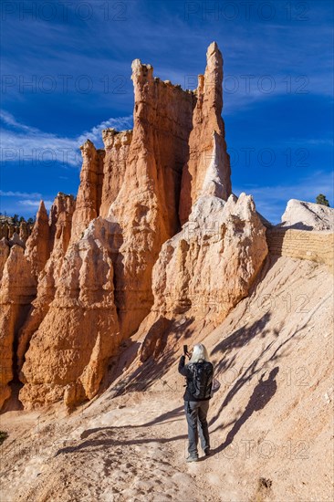 Senior hiker photographing rock formations