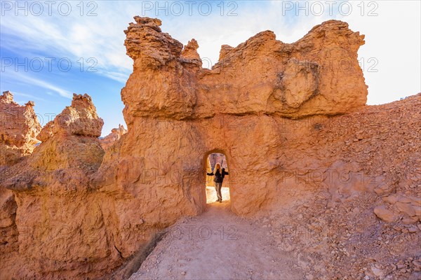 Senior hiker standing in sandstone archway