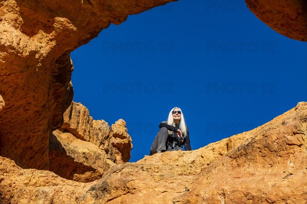 Senior hiker sitting on sandstone ledge