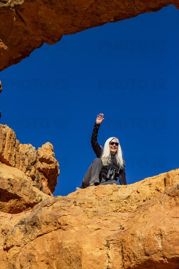 Senior hiker sitting on sandstone ledge