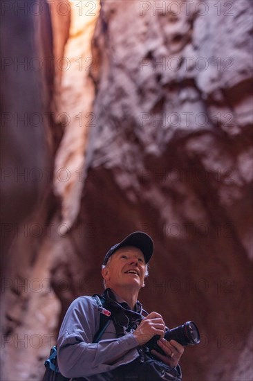 Senior male hiker with camera in canyon