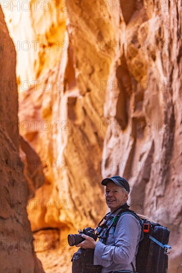 Senior hiker exploring and photographing rock formations in Kodachrome Basin State Park near Escalante Grand Staircase National Monument