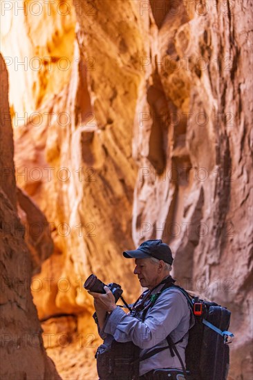 Senior hiker exploring and photographing rock formations in Kodachrome Basin State Park near Escalante Grand Staircase National Monument