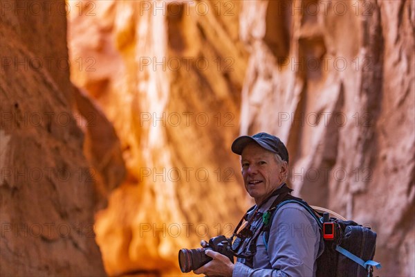 Senior hiker exploring and photographing rock formations in Kodachrome Basin State Park near Escalante Grand Staircase National Monument