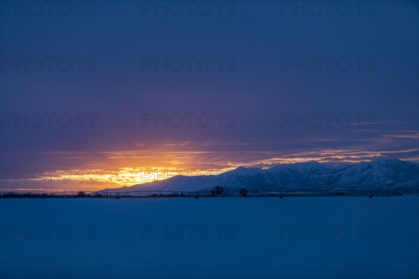 Sun rising above snowcapped mountains