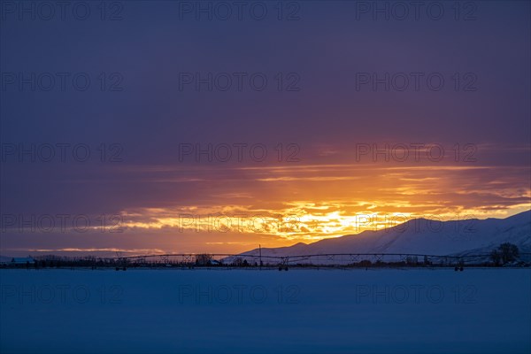 Sun rising above snowcapped mountains