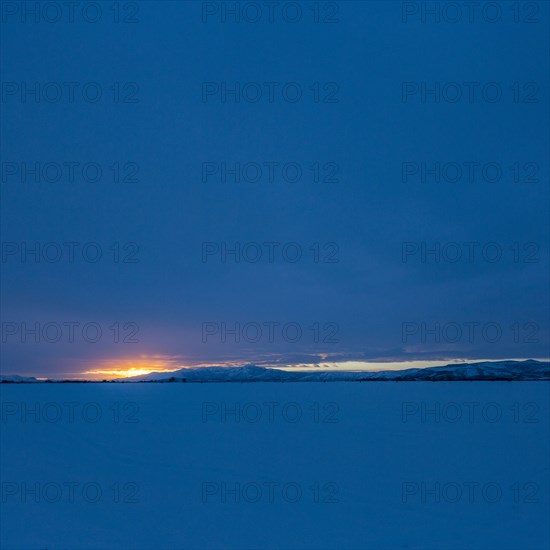 Sun rising above snowcapped mountains