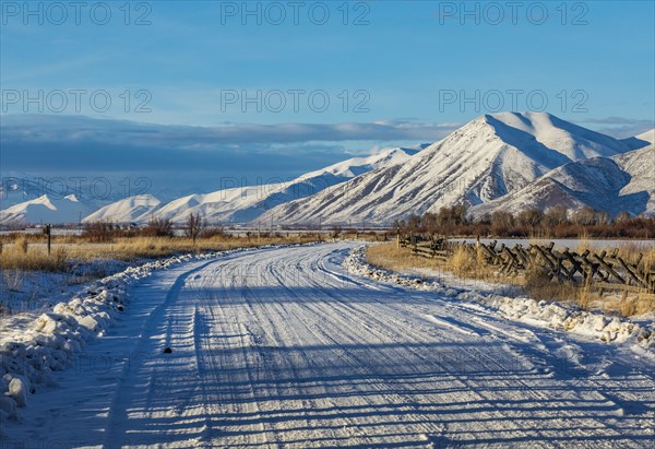 Country road leading to snowcapped mountains