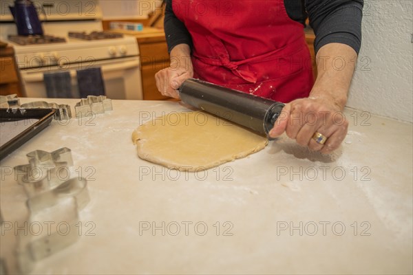 Woman baking Christmas cookies in kitchen