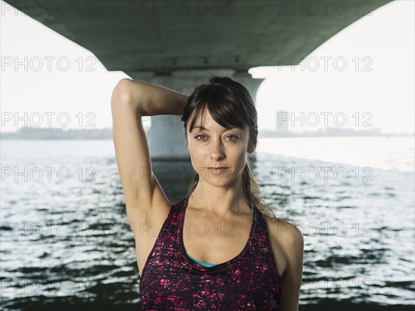 Portrait of woman in sleeveless top under bridge