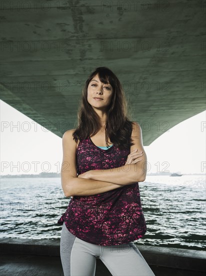 Portrait of woman in sleeveless top under bridge