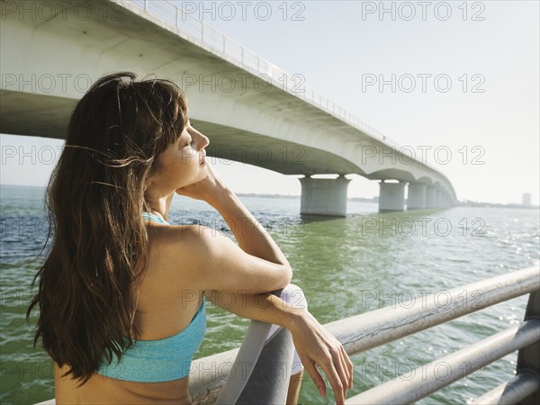 Woman relaxing on bridge on sunny day