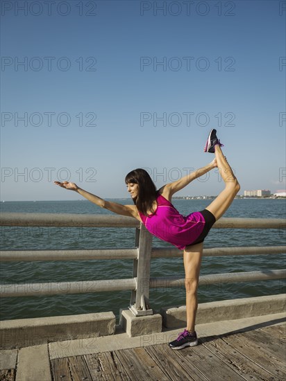 Woman stretching on bridge on sunny day