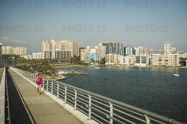 Woman jogging on bridge on sunny day