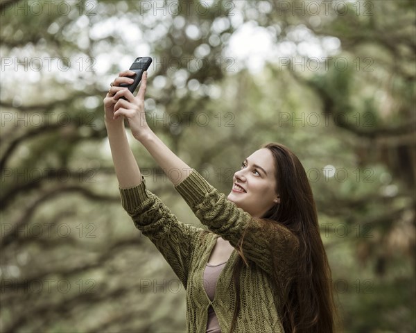 Smiling woman taking selfie in park