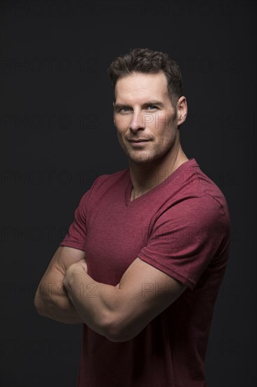 Studio portrait of serious man with arms crossed