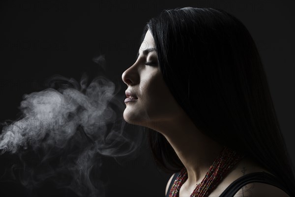 Profile of woman with smoke against black background