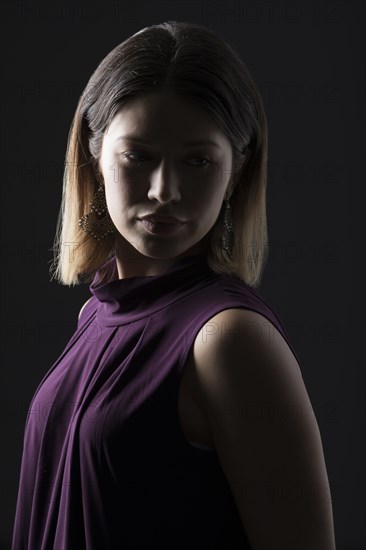 Studio portrait of woman in sleeveless purple top