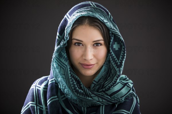 Studio portrait of smiling woman with shawl on head