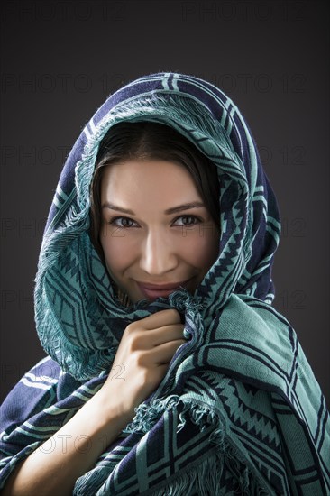 Studio portrait of smiling woman with shawl on head